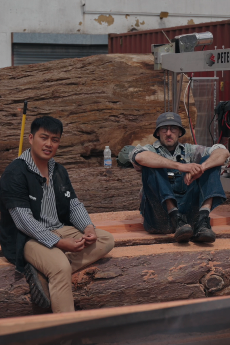 Two participants beside the large log and Peterson sawmill at the London demonstration